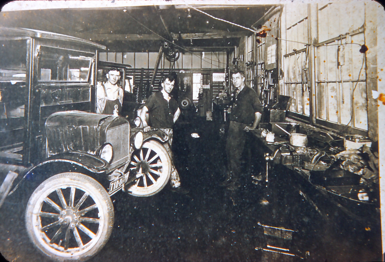 Chet working as a mechanic (he's the one in overalls standing by the hood)